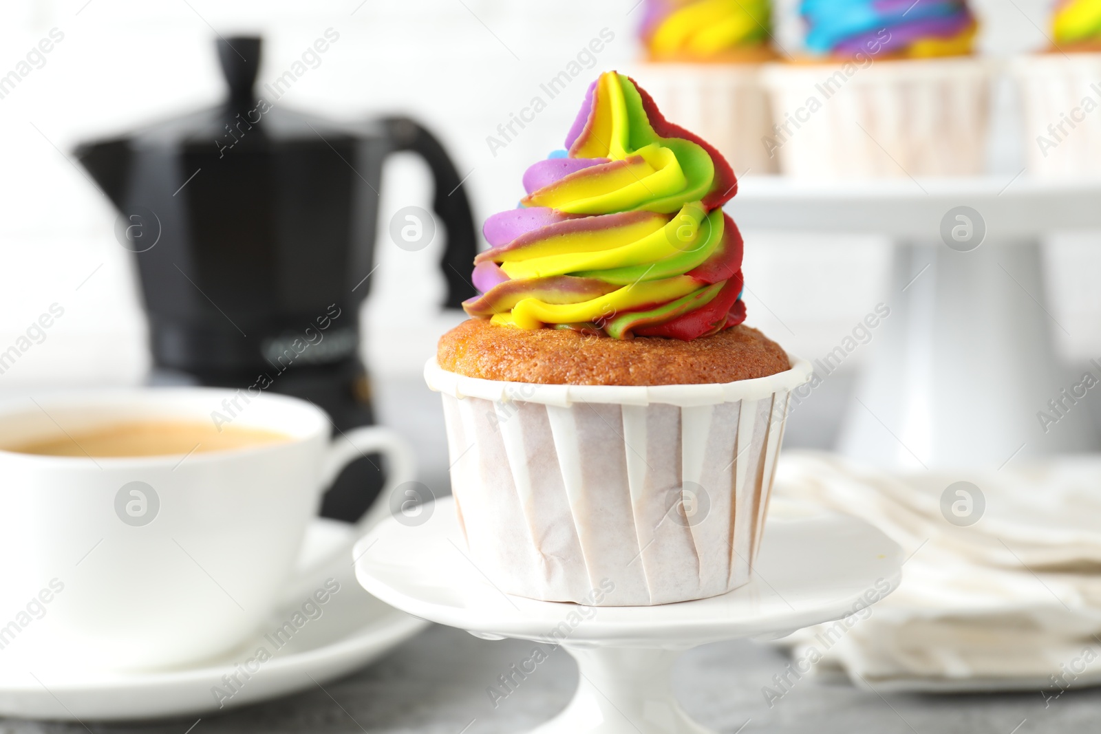 Photo of Delicious cupcake with colorful cream on stand, closeup