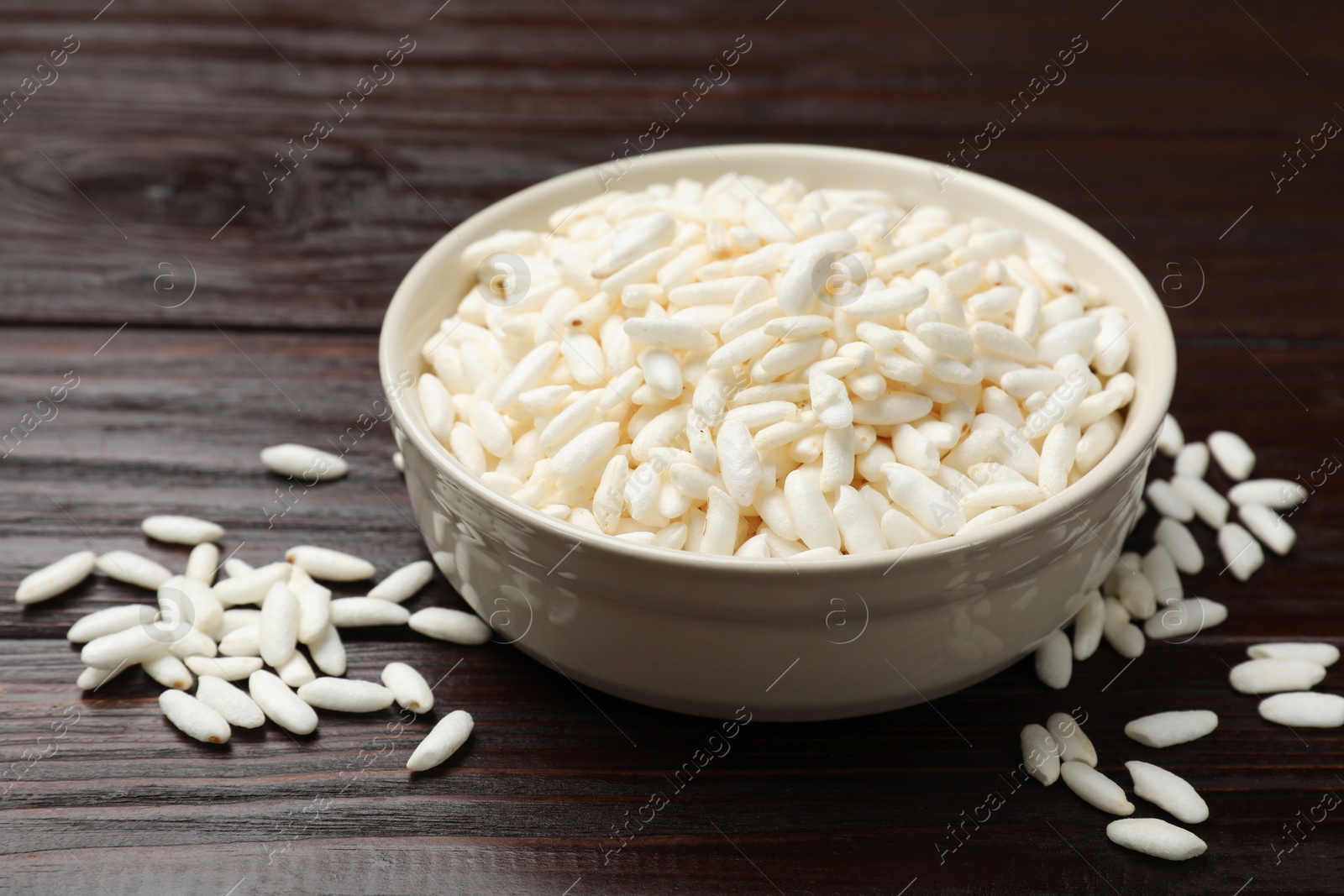 Photo of Puffed rice in bowl on wooden table, closeup