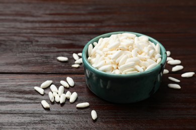 Photo of Puffed rice in bowl on wooden table, closeup. Space for text