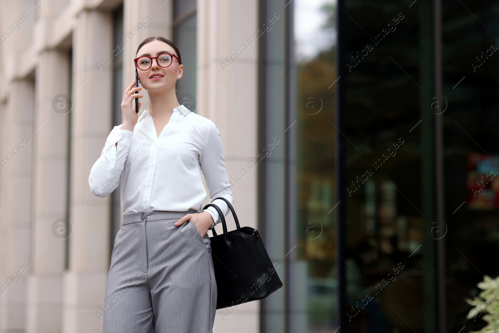 Photo of Woman in stylish outfit talking on phone outdoors. Space for text