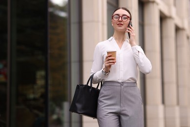 Photo of Woman in stylish outfit talking on phone outdoors. Space for text