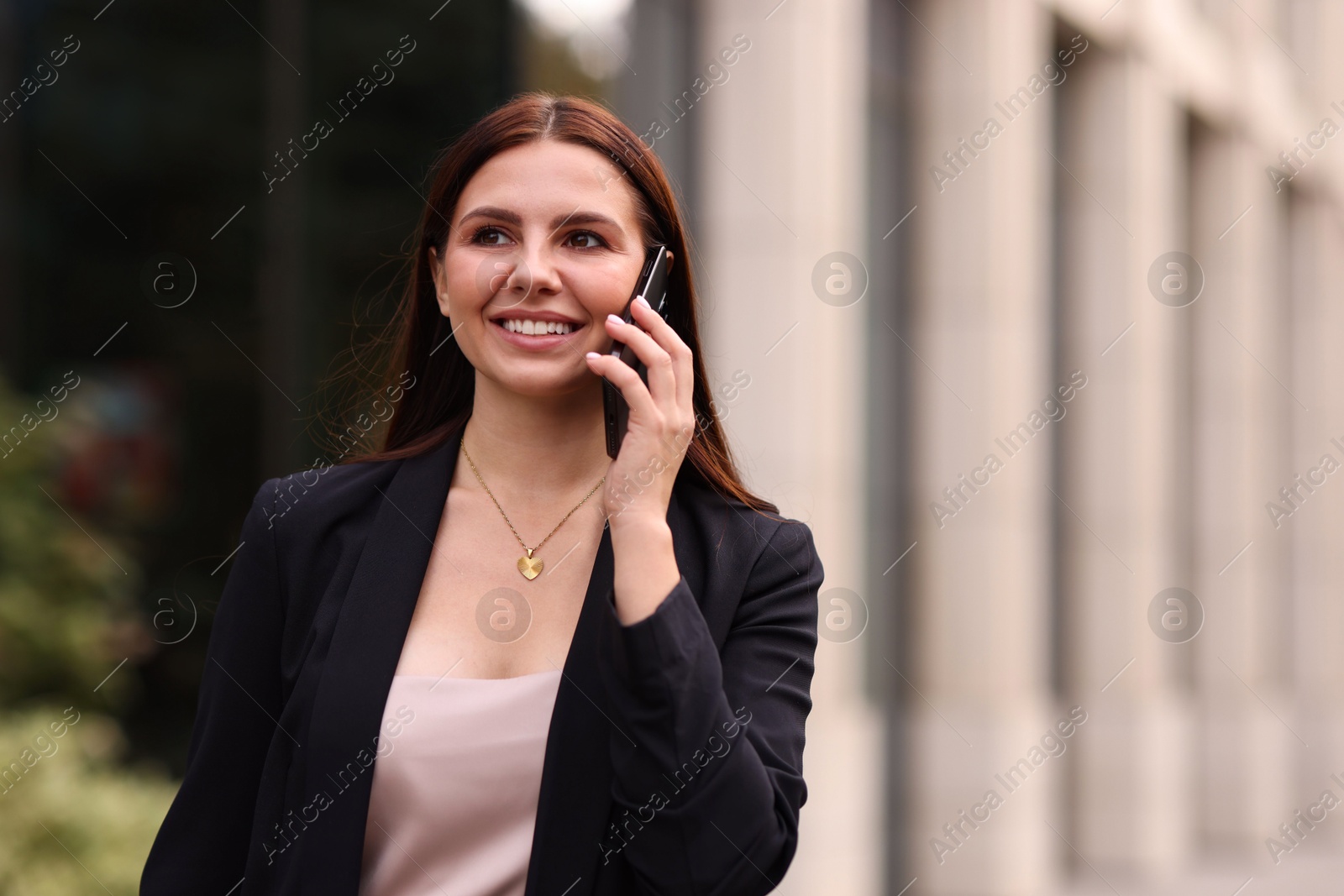 Photo of Woman in stylish formal suit talking on phone outdoors. Space for text