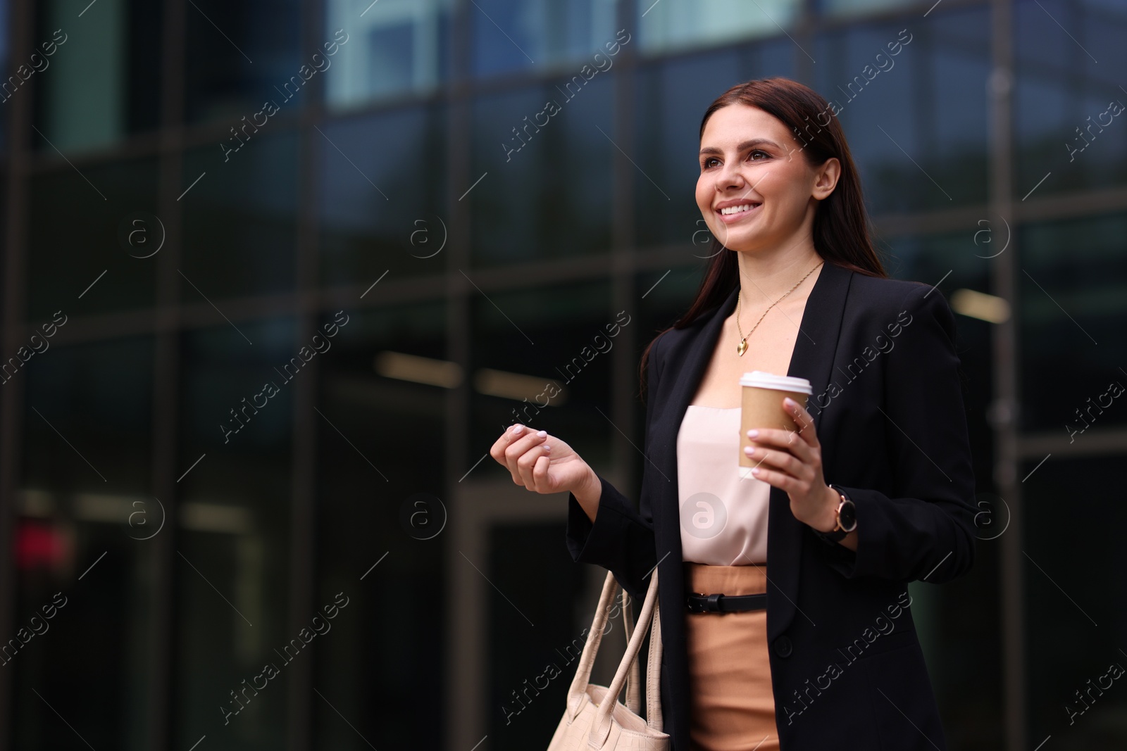 Photo of Woman in stylish formal suit with cup of coffee outdoors. Space for text