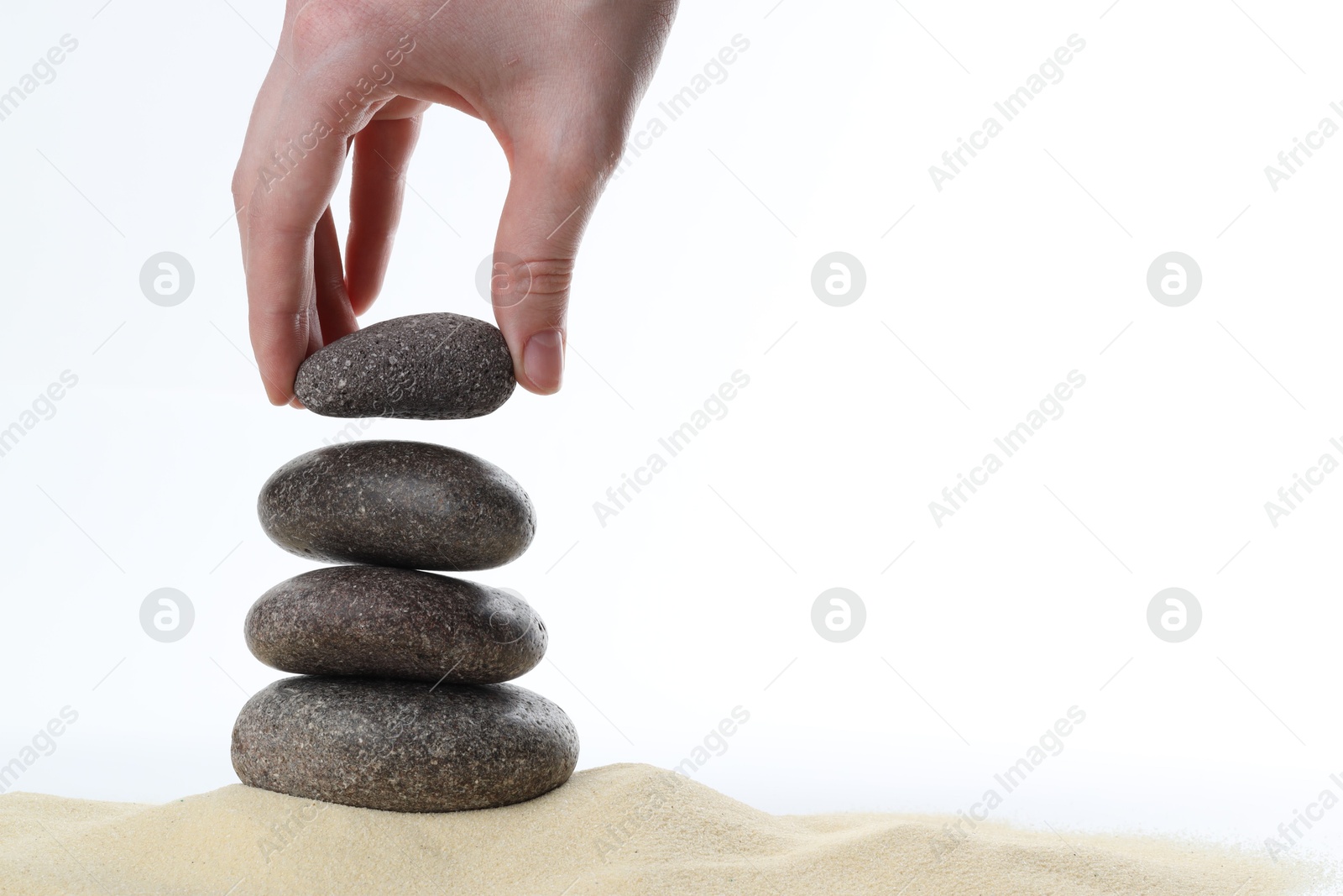 Photo of Harmony and life balance. Woman making stack of stones on white background, closeup. Space for text