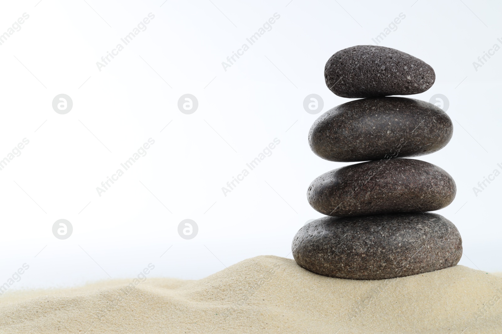 Photo of Stack of rocks on sand against white background, space for text. Harmony and life balance