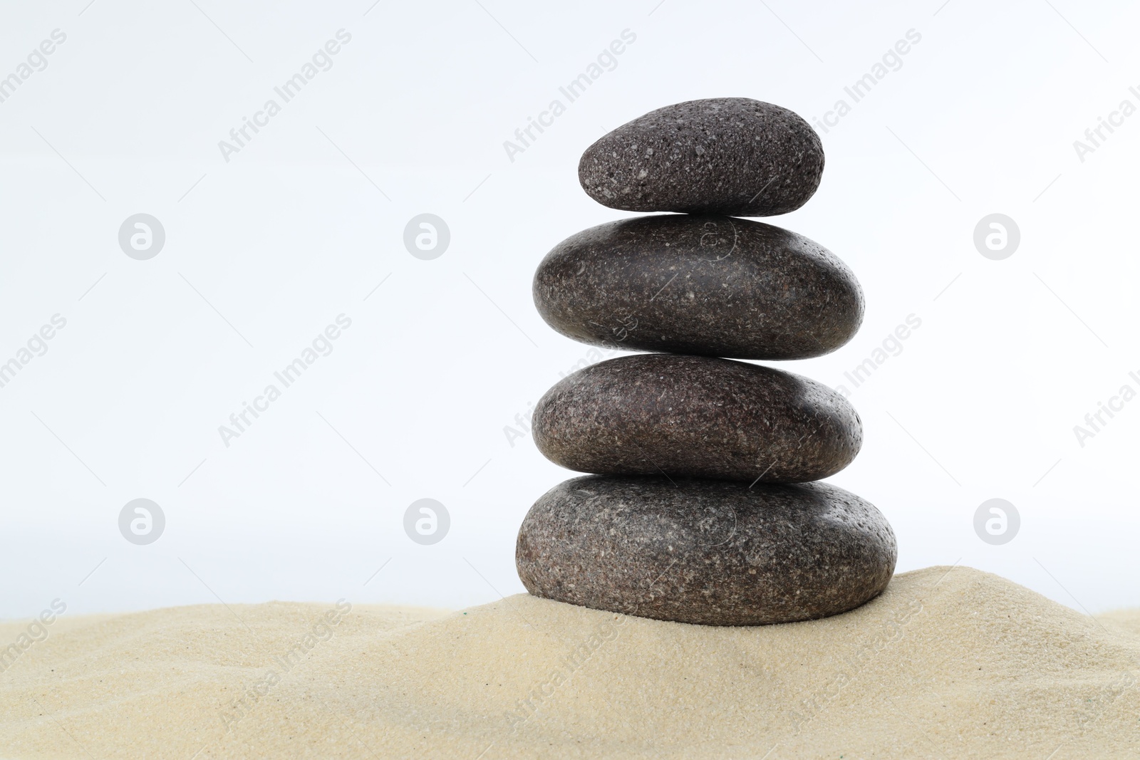 Photo of Stack of rocks on sand against white background, space for text. Harmony and life balance