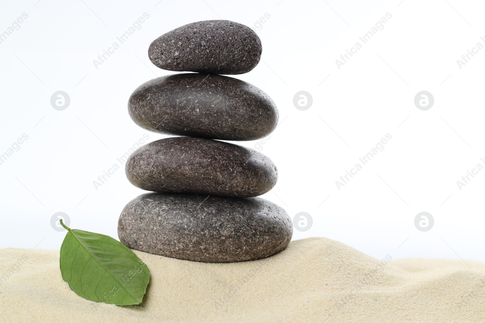 Photo of Stack of rocks on sand against white background. Harmony and life balance