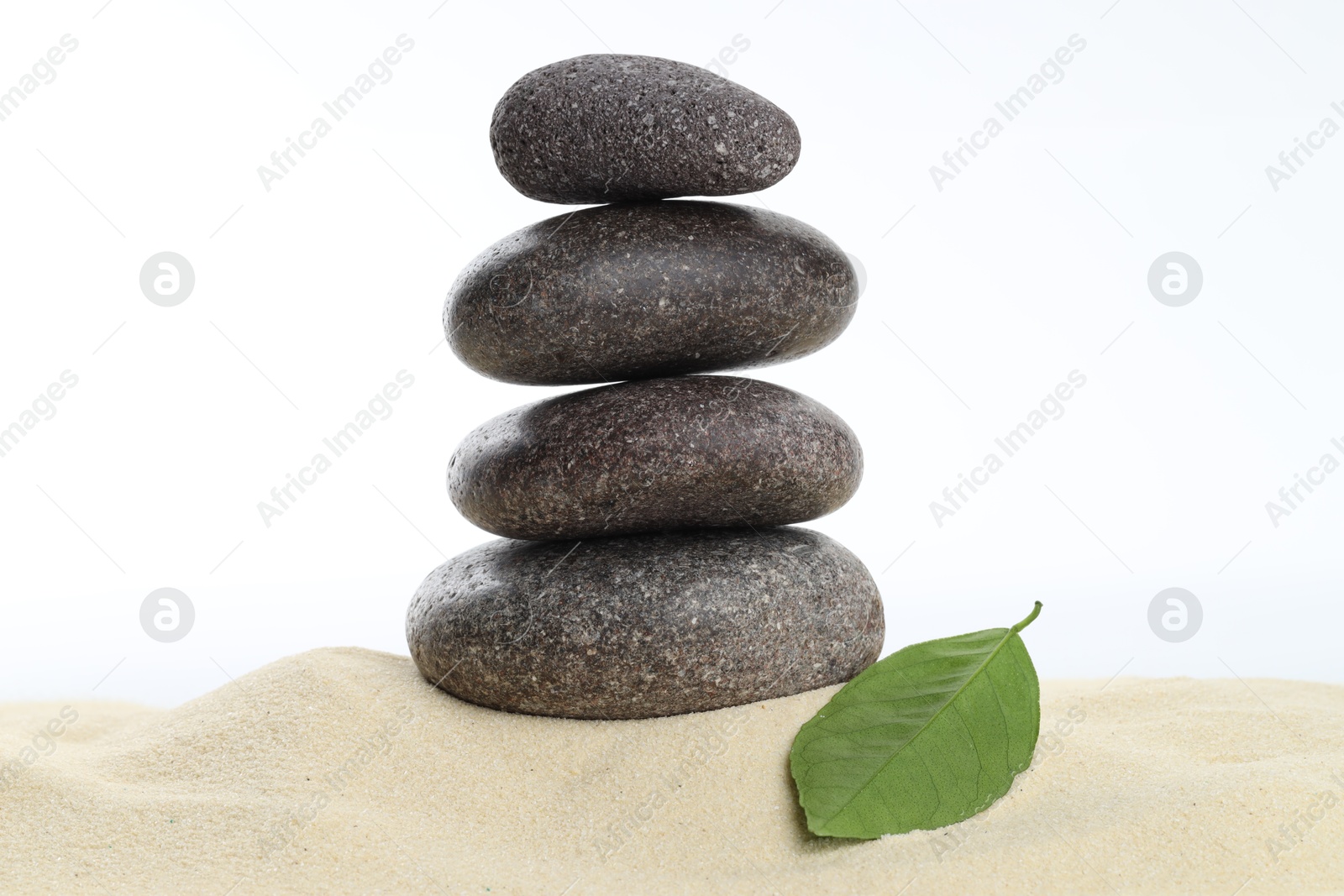 Photo of Stack of rocks on sand against white background. Harmony and life balance