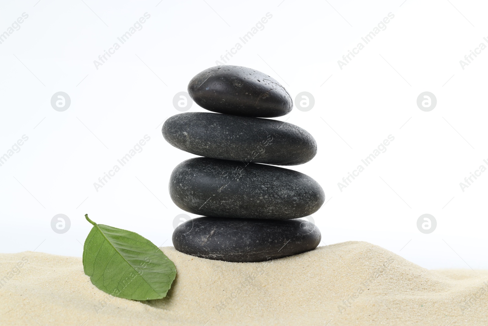 Photo of Stack of rocks on sand against white background. Harmony and life balance