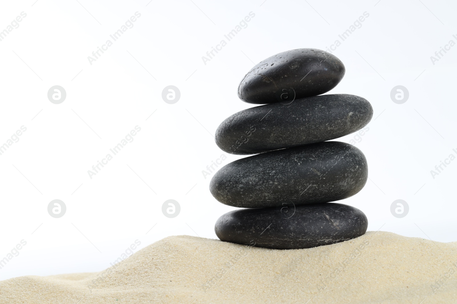 Photo of Stack of rocks on sand against white background, space for text. Harmony and life balance