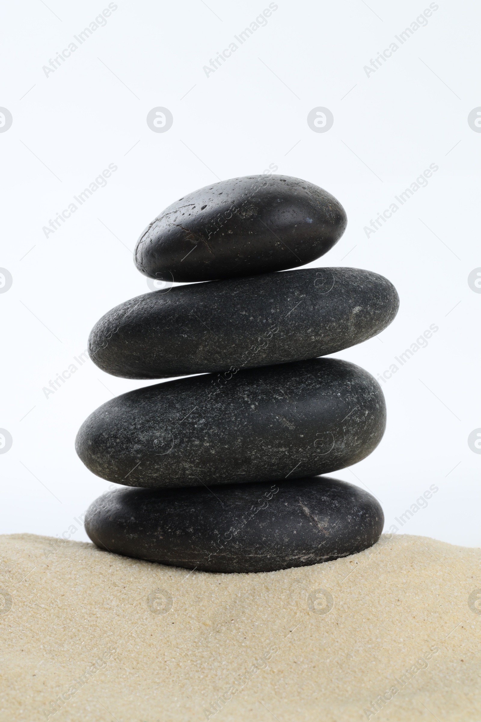 Photo of Stack of rocks on sand against white background. Harmony and life balance