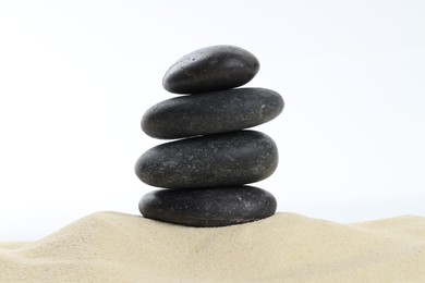 Photo of Stack of rocks on sand against white background. Harmony and life balance