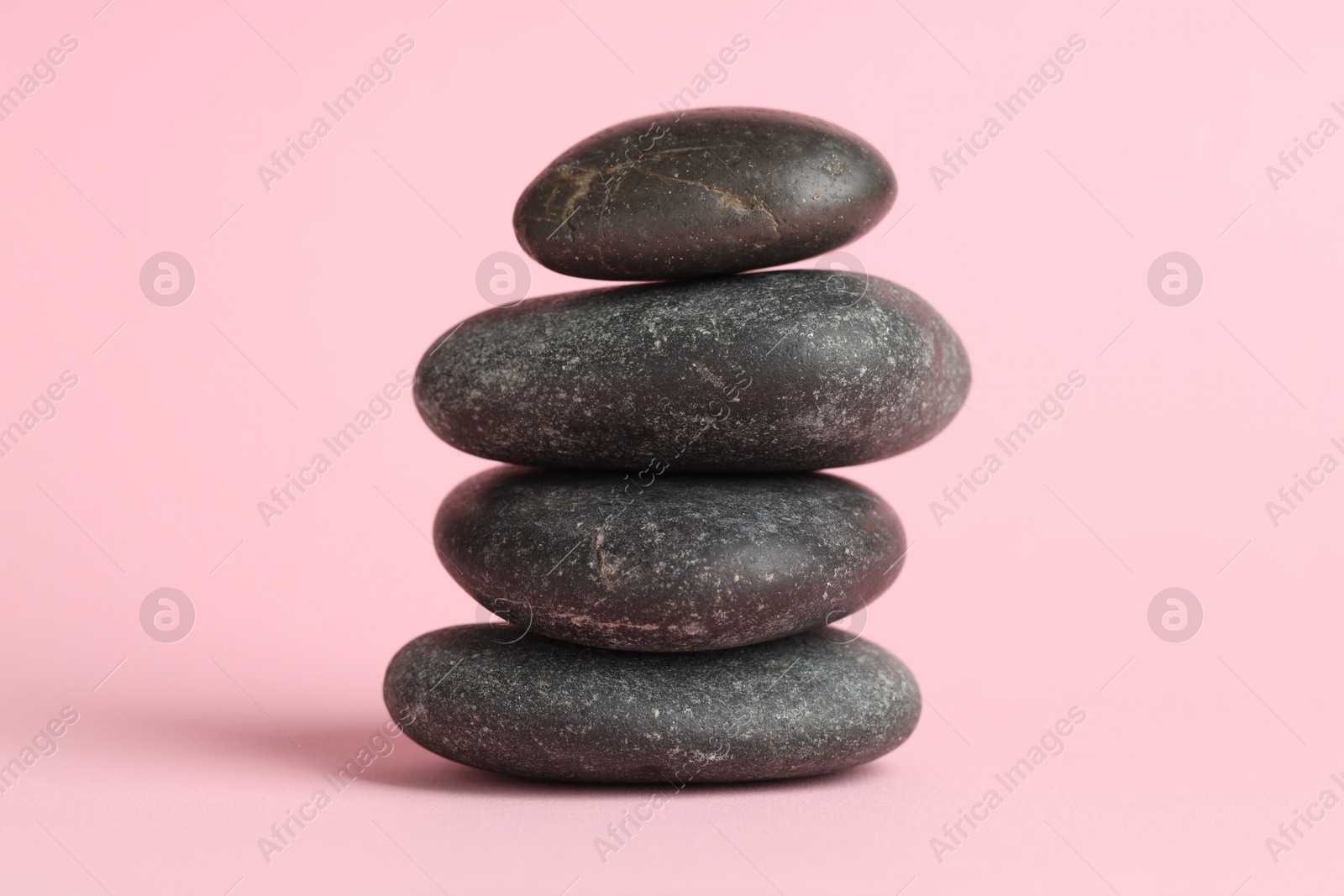 Photo of Stack of rocks on pink background. Harmony and life balance