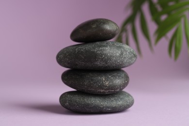 Photo of Stack of rocks on lilac background. Harmony and life balance