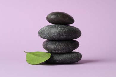 Photo of Stack of rocks on lilac background. Harmony and life balance