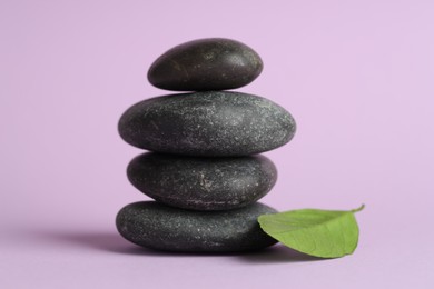 Photo of Stack of rocks on lilac background. Harmony and life balance