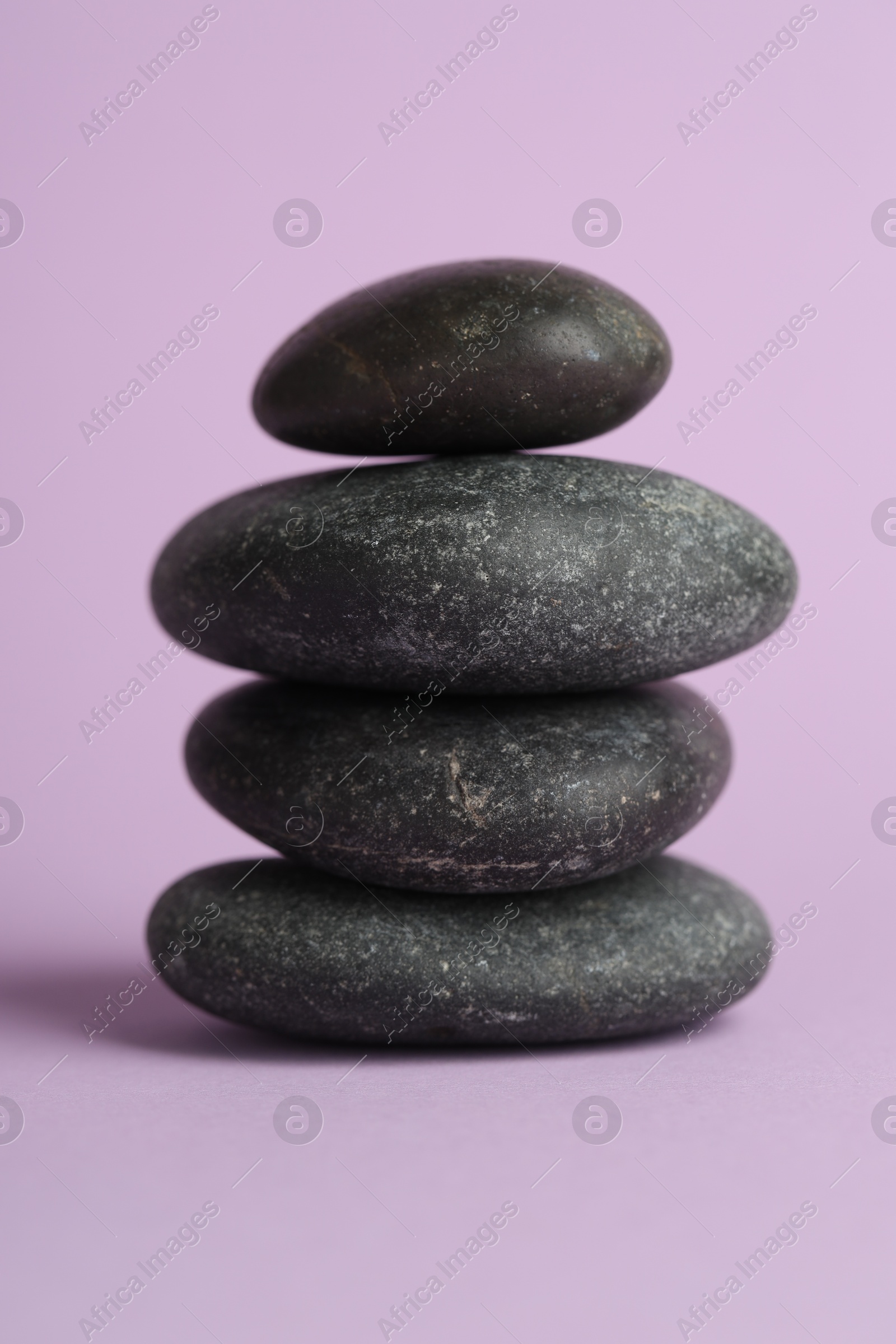 Photo of Stack of rocks on lilac background. Harmony and life balance