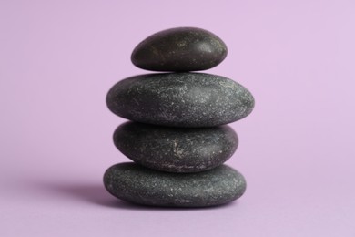 Photo of Stack of rocks on lilac background. Harmony and life balance