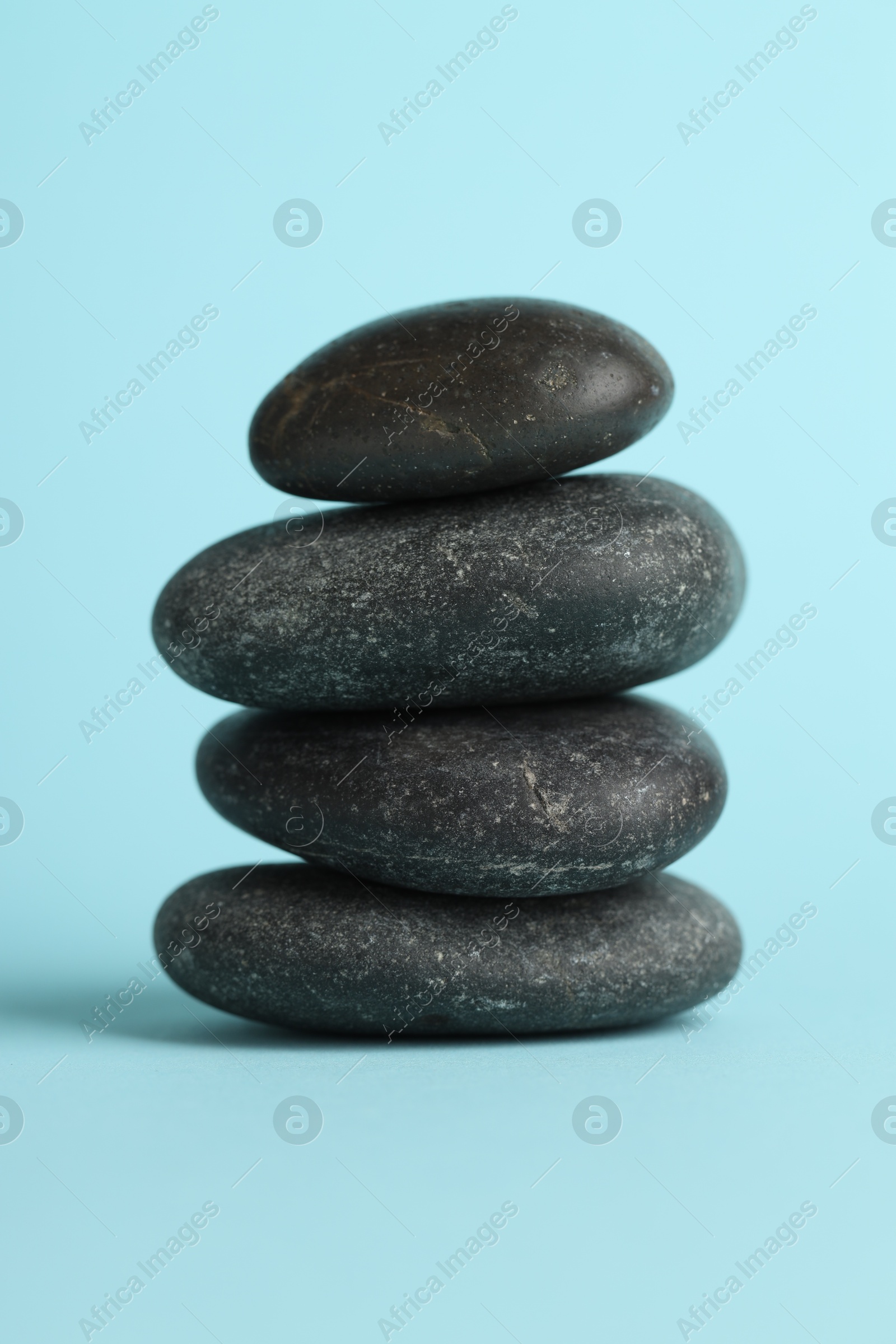 Photo of Stack of rocks on light blue background. Harmony and life balance