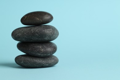 Photo of Stack of rocks on light blue background, space for text. Harmony and life balance