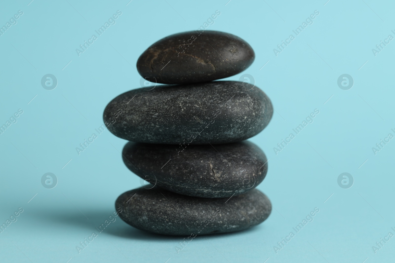 Photo of Stack of rocks on light blue background. Harmony and life balance