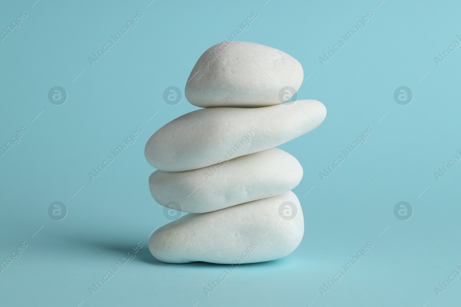 Photo of Stack of rocks on light blue background. Harmony and life balance