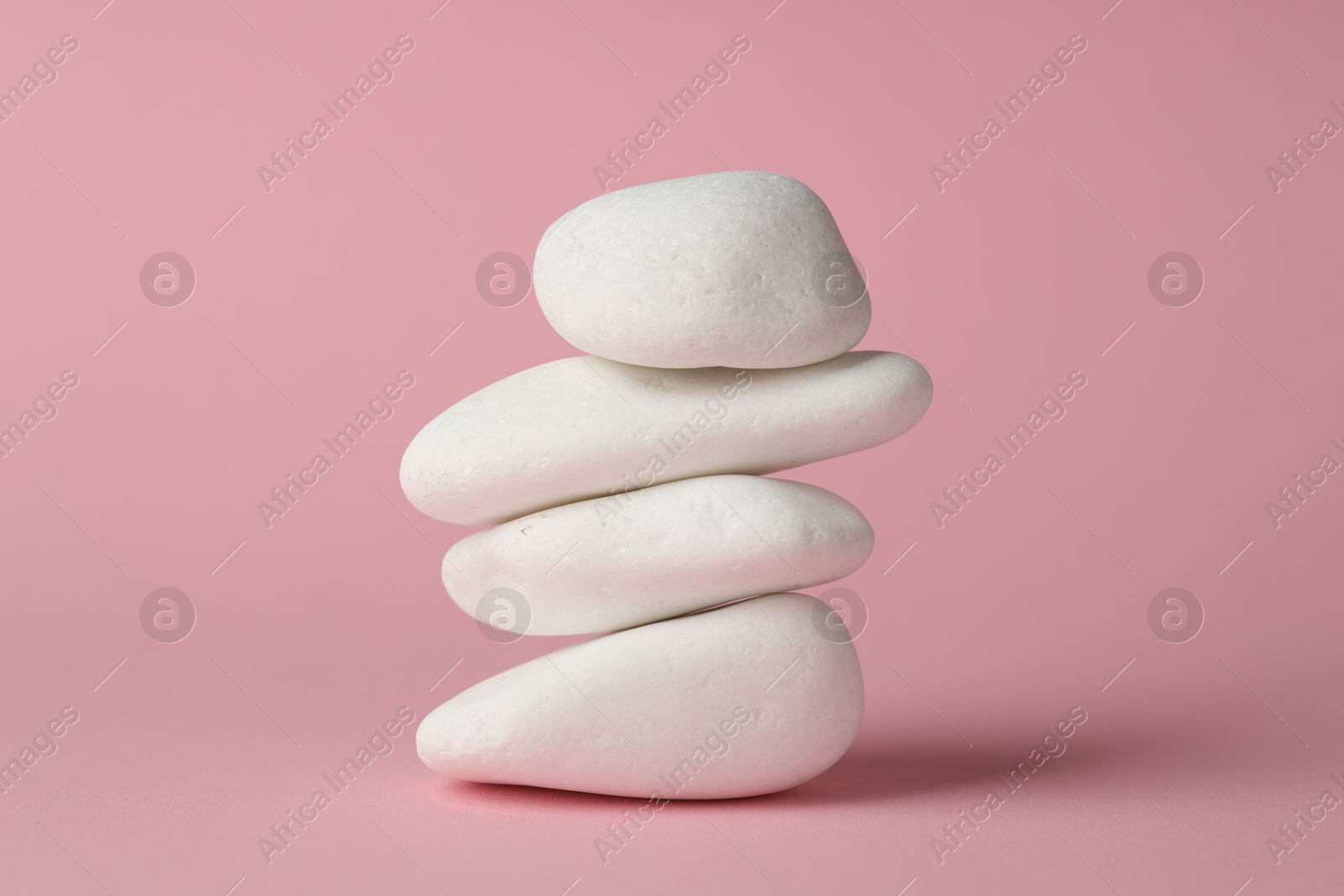 Photo of Stack of rocks on pink background. Harmony and life balance