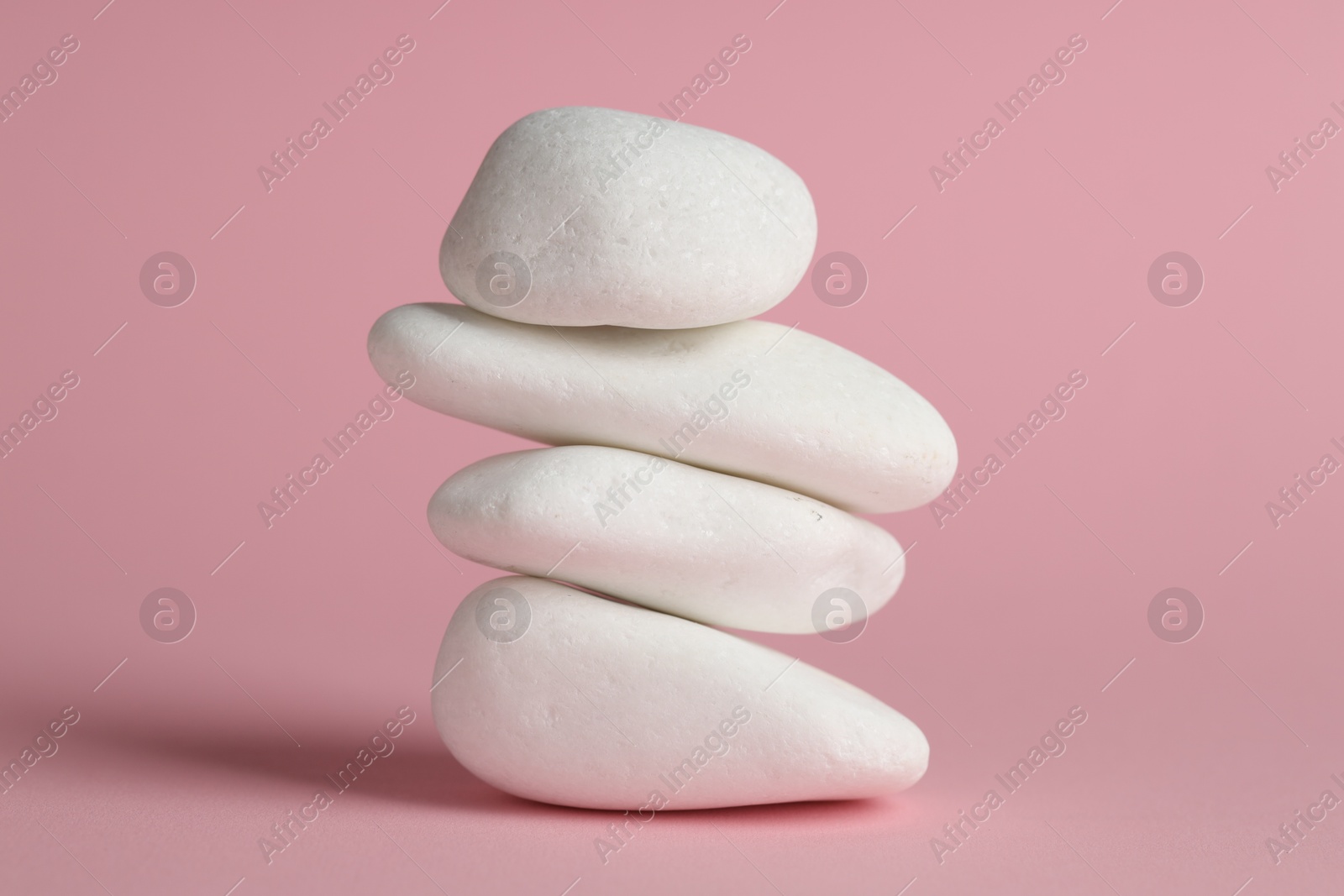 Photo of Stack of rocks on pink background. Harmony and life balance