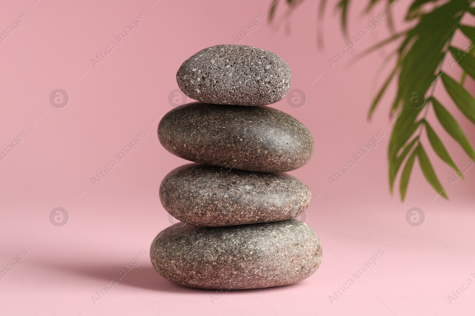 Photo of Stack of rocks on pink background. Harmony and life balance