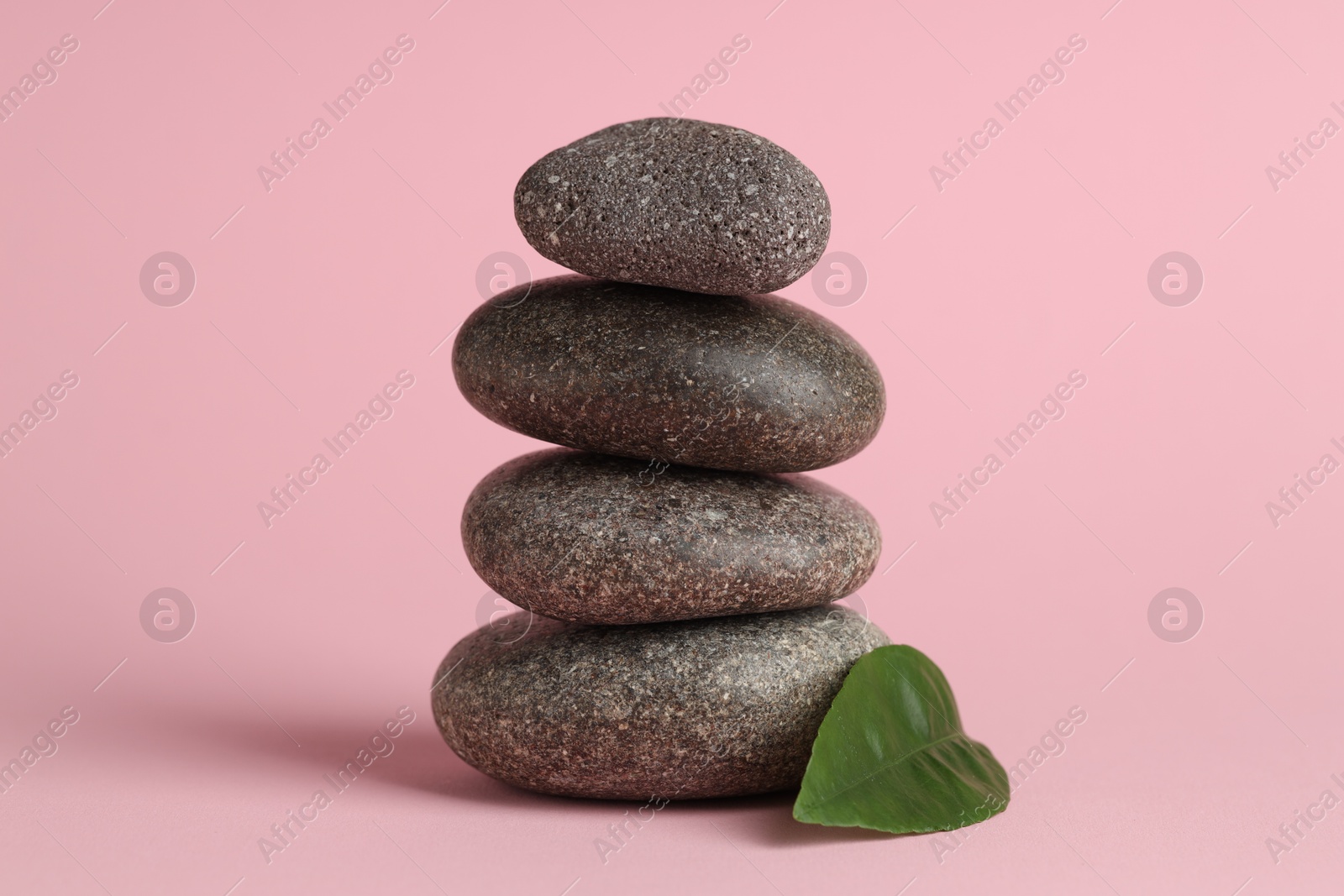 Photo of Stack of rocks on pink background. Harmony and life balance