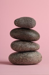 Photo of Stack of rocks on pink background. Harmony and life balance