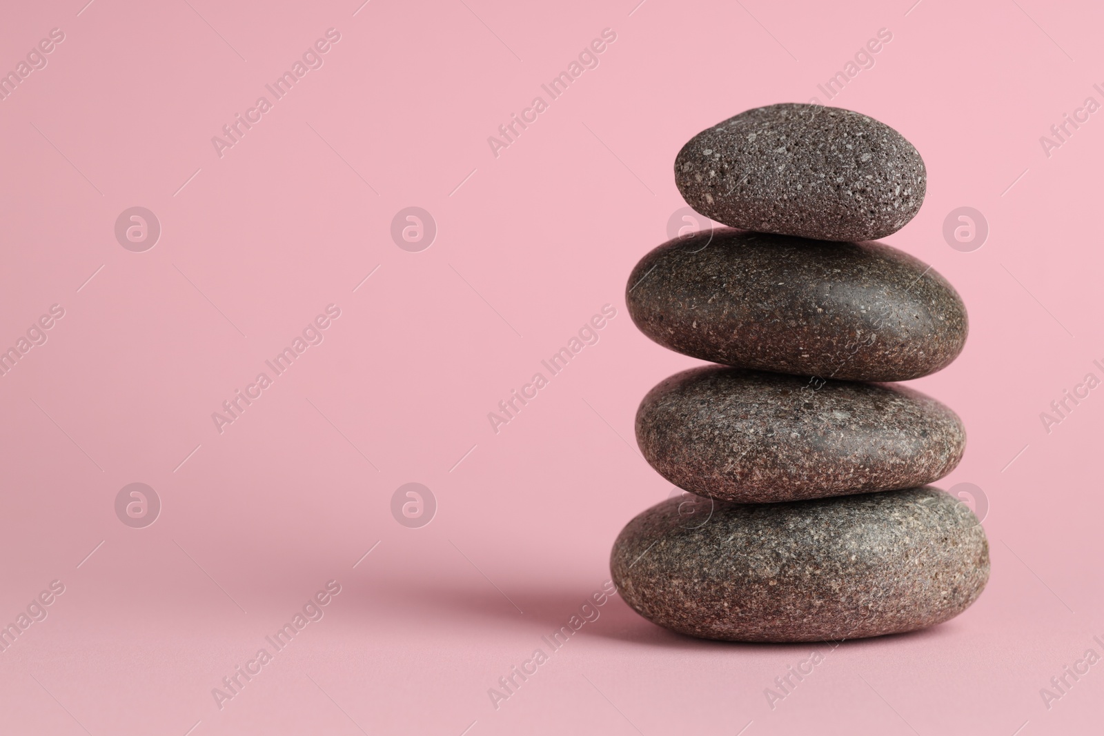 Photo of Stack of rocks on pink background. Harmony and life balance