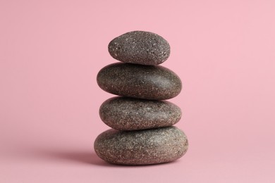 Photo of Stack of rocks on pink background. Harmony and life balance