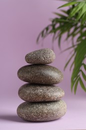 Photo of Stack of rocks on lilac background. Harmony and life balance