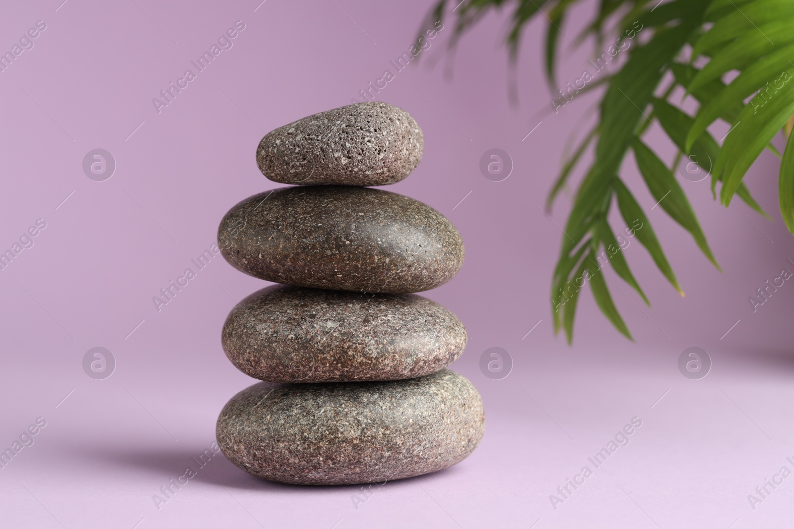 Photo of Stack of rocks on lilac background. Harmony and life balance