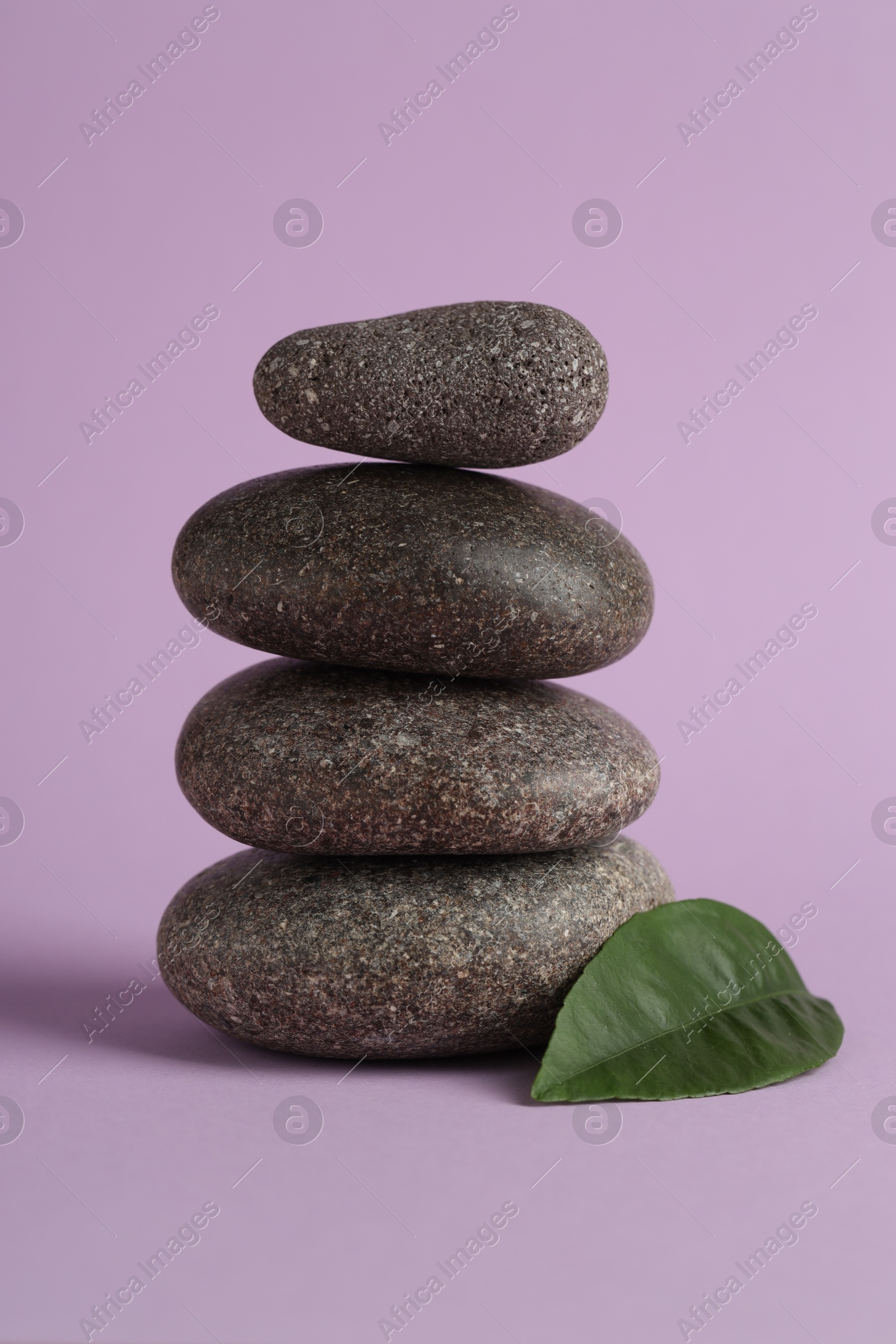 Photo of Stack of rocks on lilac background. Harmony and life balance