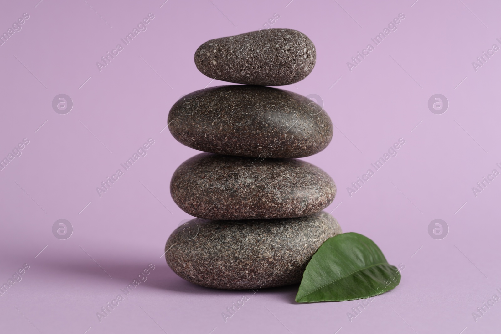 Photo of Stack of rocks on lilac background. Harmony and life balance