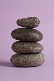 Photo of Stack of rocks on lilac background. Harmony and life balance