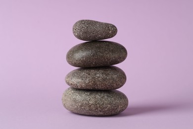 Photo of Stack of rocks on lilac background. Harmony and life balance