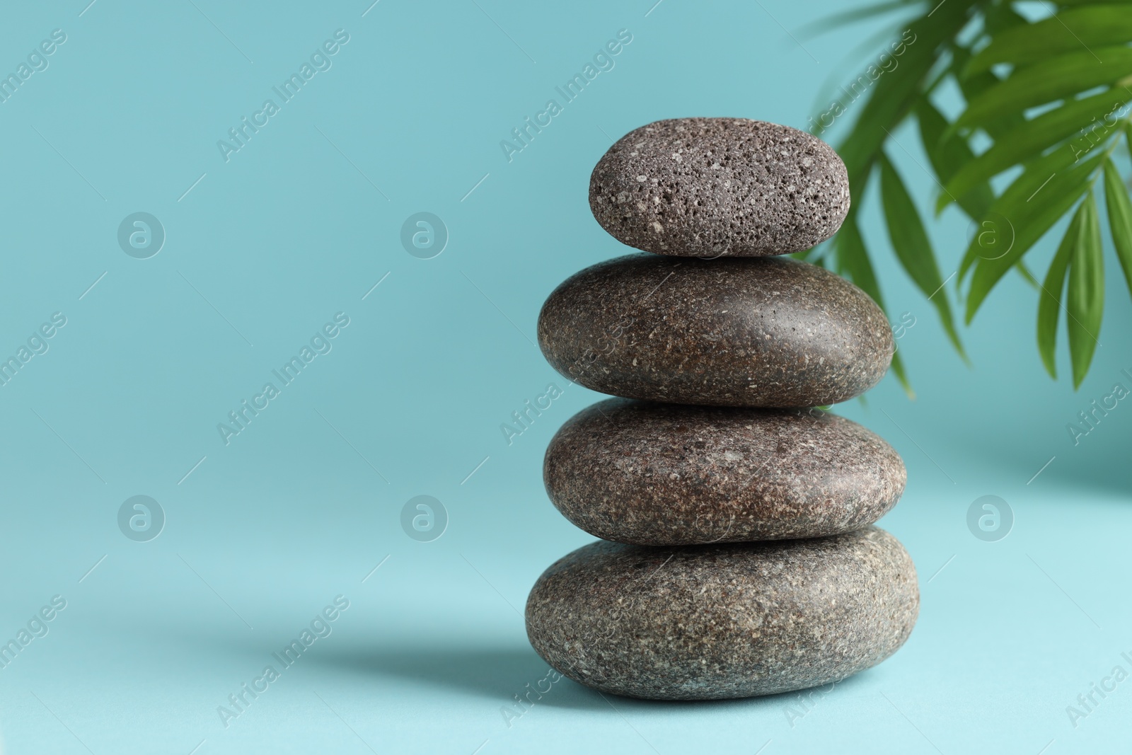 Photo of Stack of rocks on light blue background, space for text. Harmony and life balance