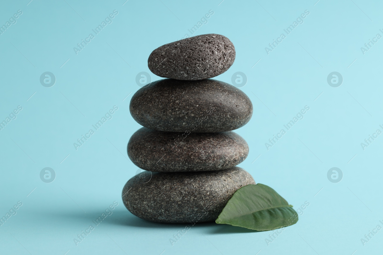 Photo of Stack of rocks on light blue background. Harmony and life balance