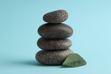 Photo of Stack of rocks on light blue background. Harmony and life balance