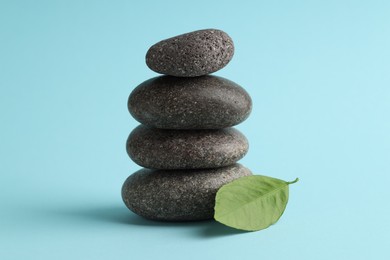 Photo of Stack of rocks on light blue background. Harmony and life balance