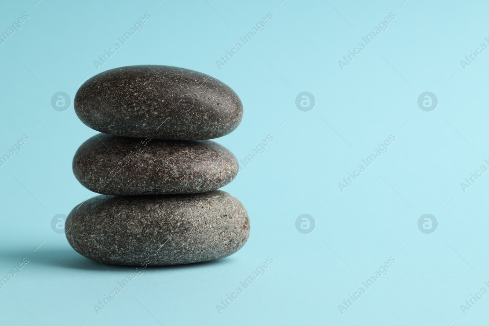 Photo of Stack of rocks on light blue background, space for text. Harmony and life balance