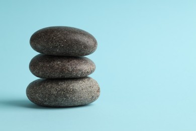 Photo of Stack of rocks on light blue background, space for text. Harmony and life balance