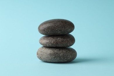 Photo of Stack of rocks on light blue background. Harmony and life balance