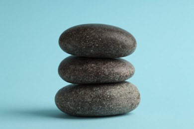 Photo of Stack of rocks on light blue background. Harmony and life balance