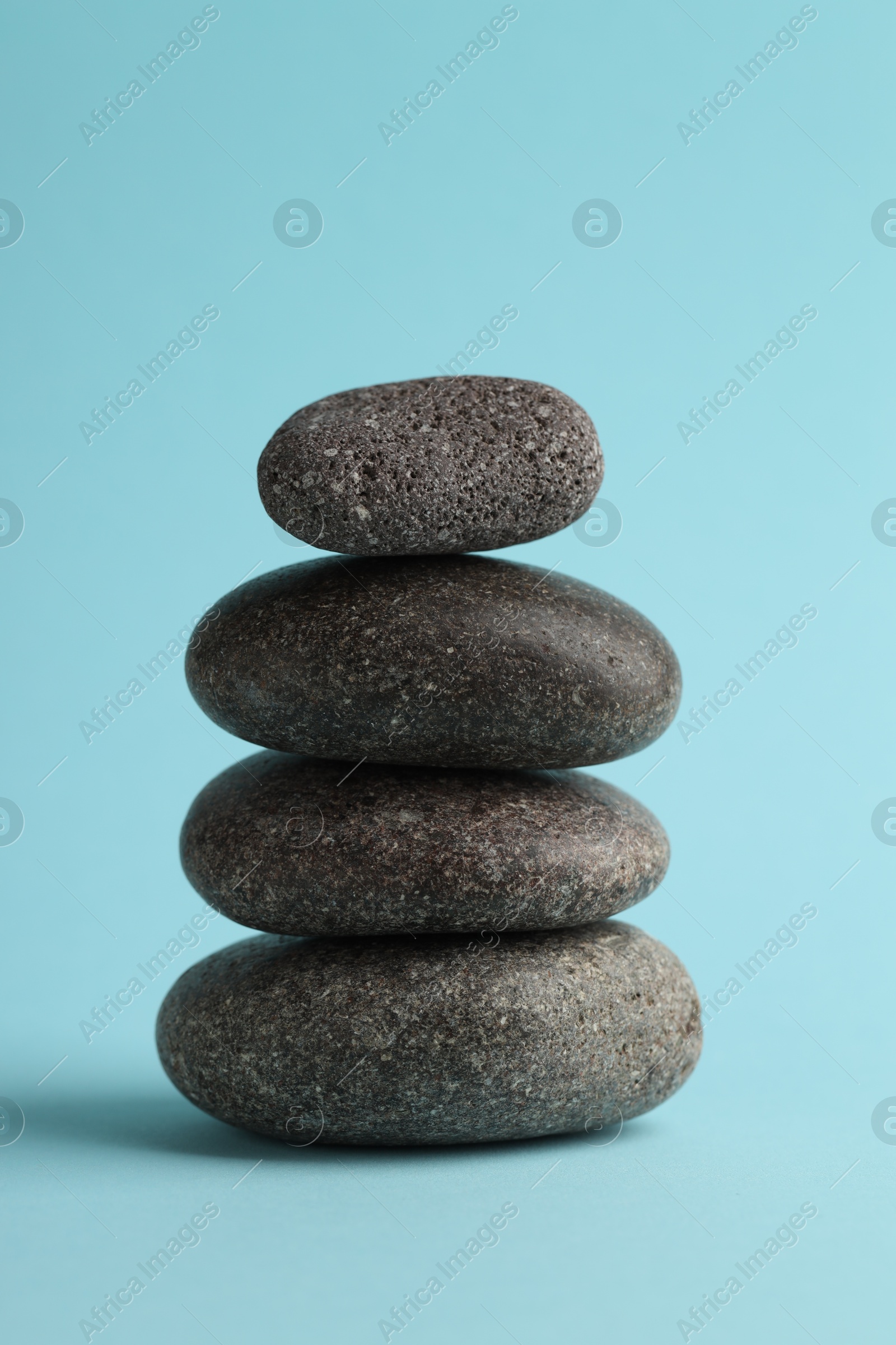 Photo of Stack of rocks on light blue background. Harmony and life balance