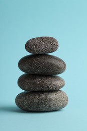 Photo of Stack of rocks on light blue background. Harmony and life balance