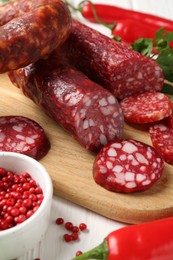 Photo of Different smoked sausages and spices on table, closeup